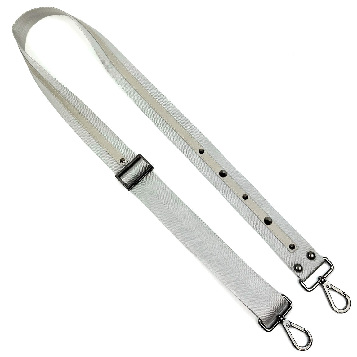 The SHOULDER STRAP - LIGHT GREY by evokewomen is a versatile accessory, crafted from durable nylon webbing in a light grey color. It features gunmetal accents, metal clasps, and sleek rivets for added style.