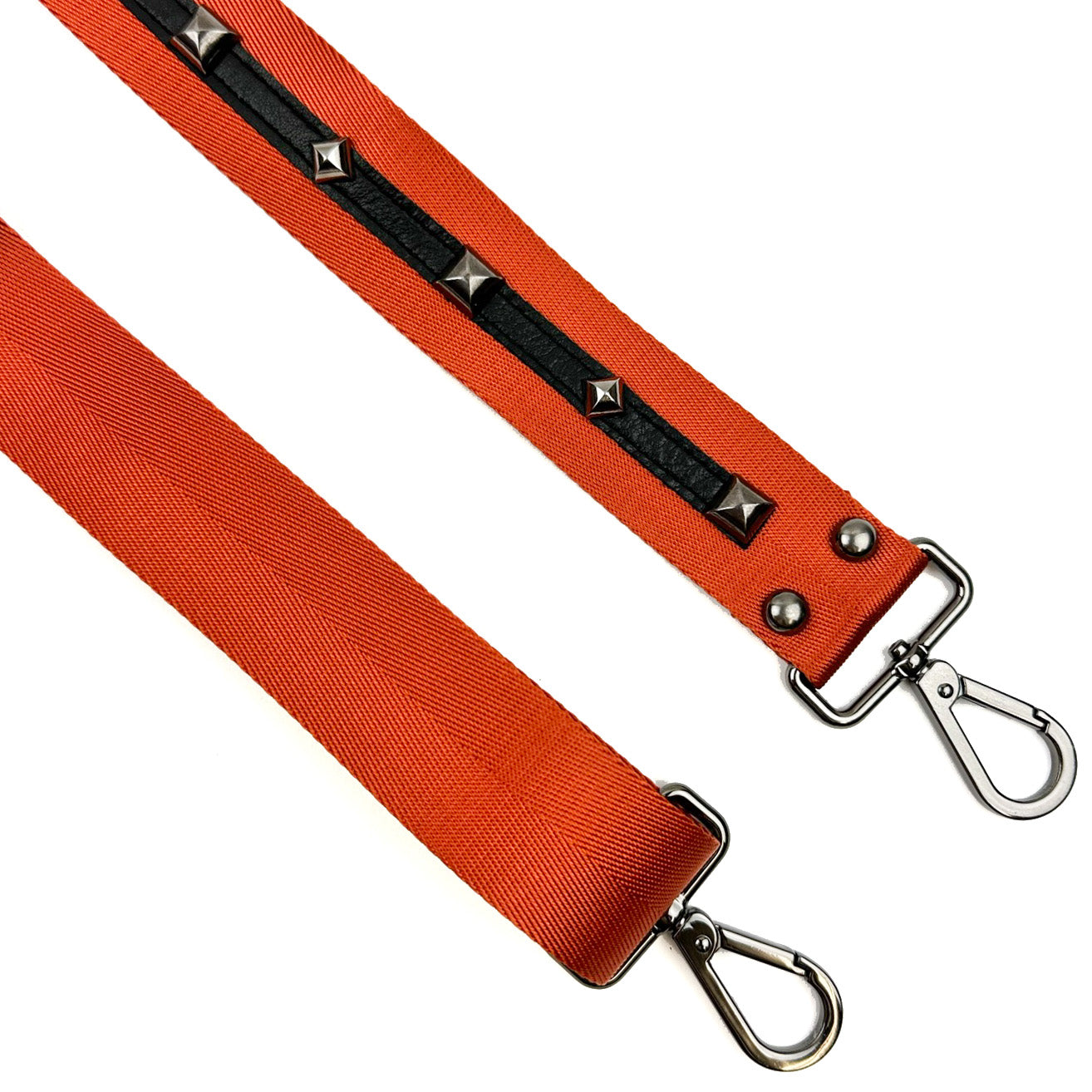 The "SHOULDER STRAP - ORANGE" by evokewomen features two detachable orange bag straps with silver clasps, with one showcasing a unique design accented in black and adorned with studs.