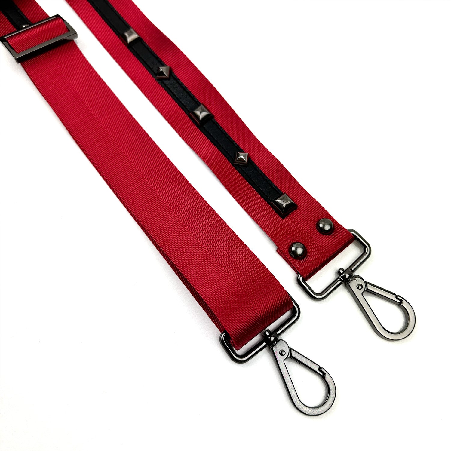 Two SHOULDER STRAP - RED by evokewomen featuring metal clasps and nylon webbing. One strap is designed with black accents and silver studs.