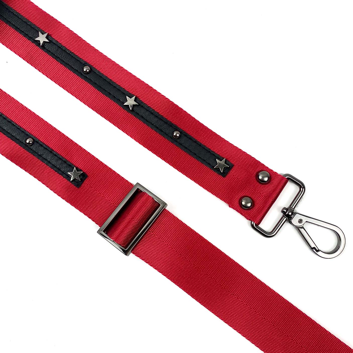 The evokewomen SHOULDER STRAP - RED + stars features a red design with black detailing, adorned with silver stars, and includes a metal buckle accented with leather embellishments and a clip at one end.