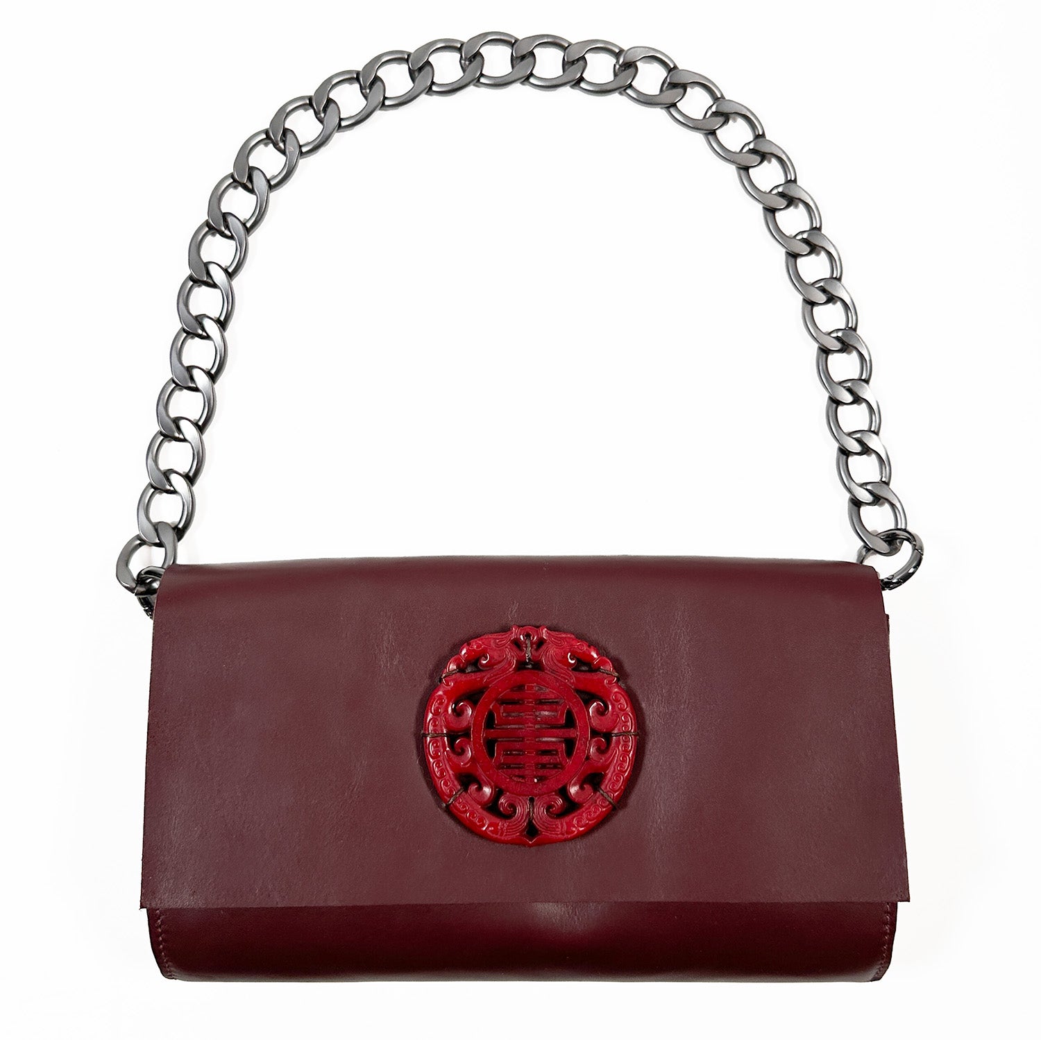 A burgundy Italian leather shoulder bag from evokewomen called BAGUETTE, featuring a large chain strap and a striking red ornamental decoration on the front flap.