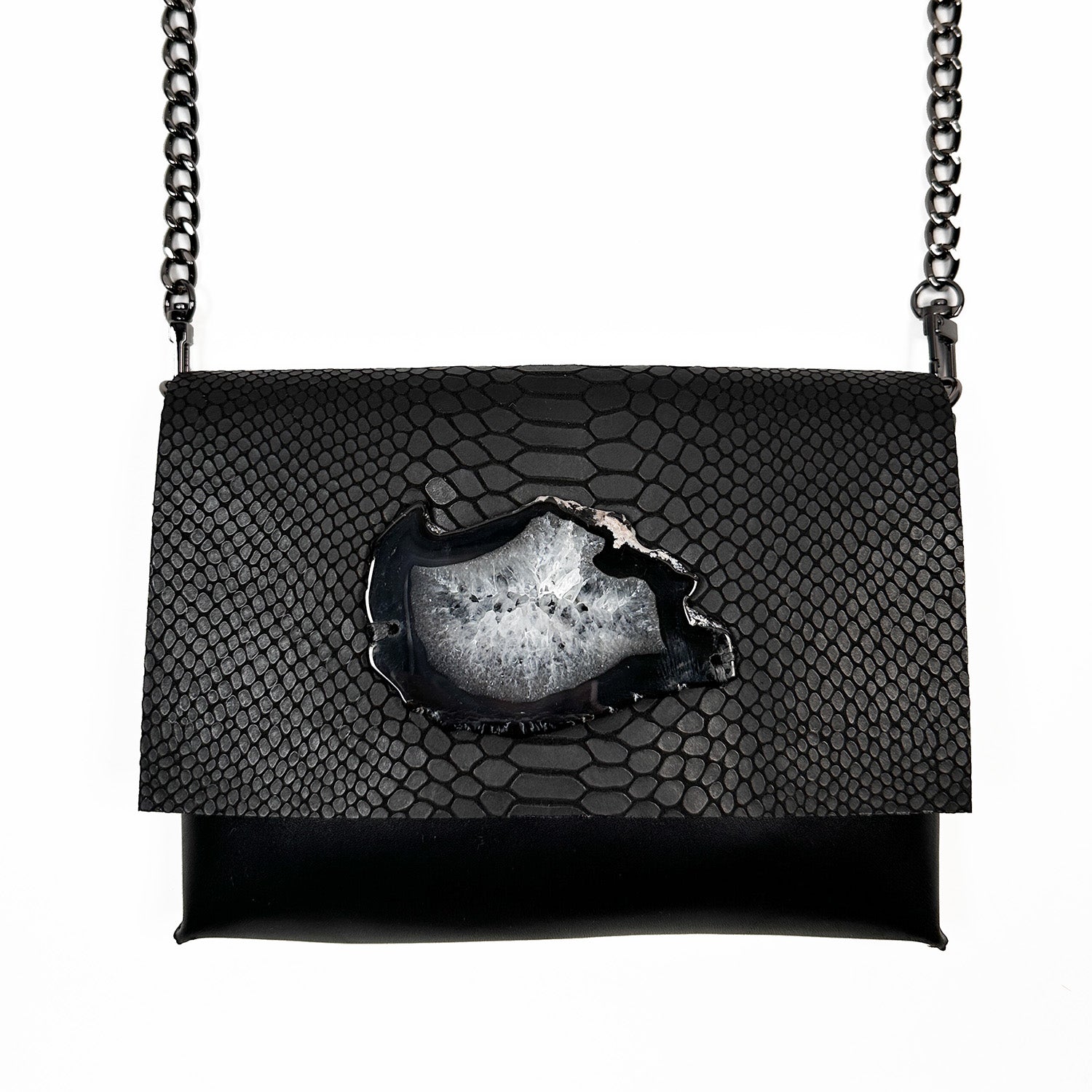 Introducing the BAHAMA – black snake look - shoulder bag by evokewomen, a versatile piece crafted from premium matte faux snake Italian leather adorned with a striking agate. This elegant bag is accented with a chic gunmetal chain strap and is beautifully showcased against a crisp white backdrop.