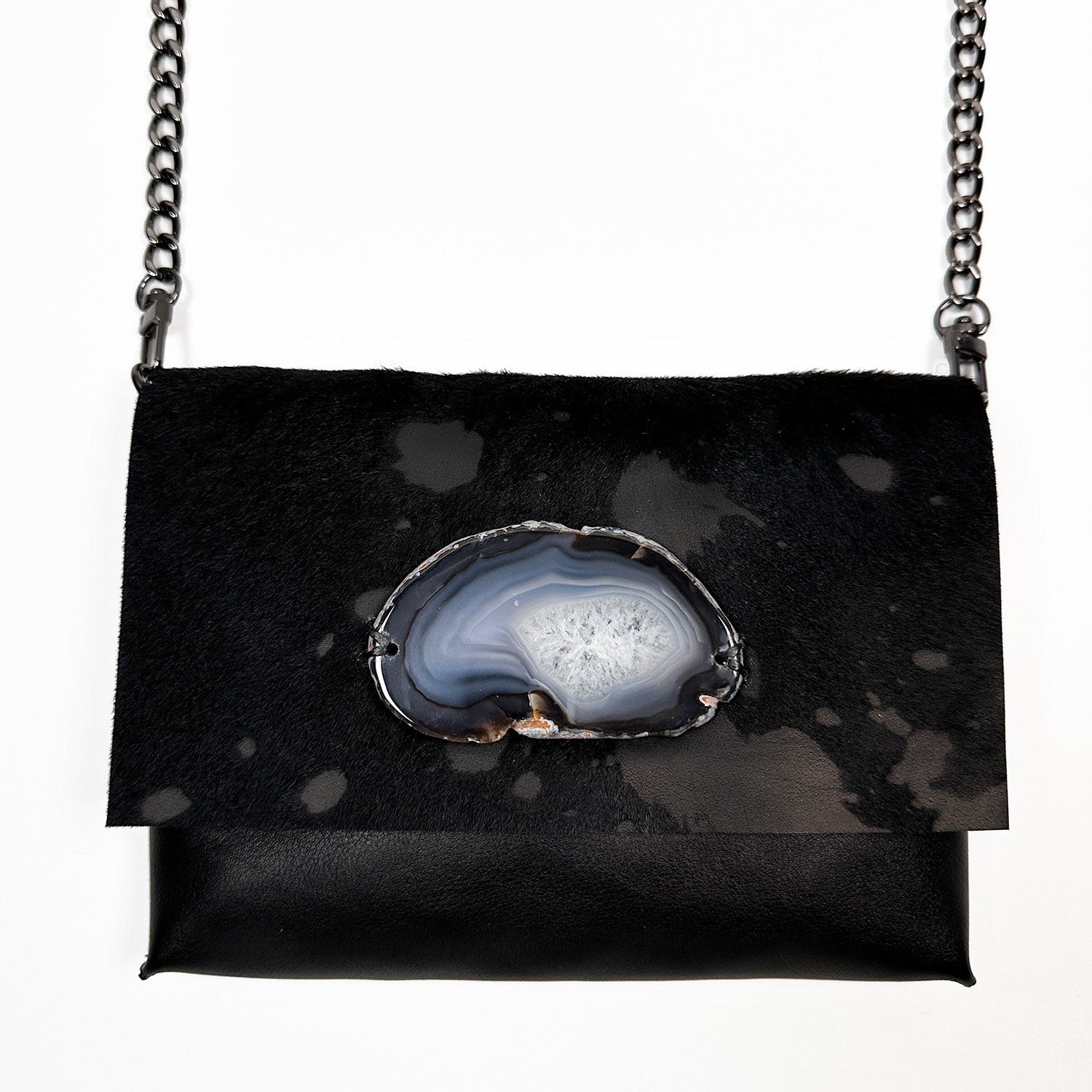 Introducing the BAHAMA – BLACK FUR FLAP shoulder bag by evokewomen, a versatile piece crafted from premium black Italian leather and adorned with an Agate stone. This elegant bag is accented with a chic gunmetal chain strap and is beautifully showcased against a crisp white backdrop.