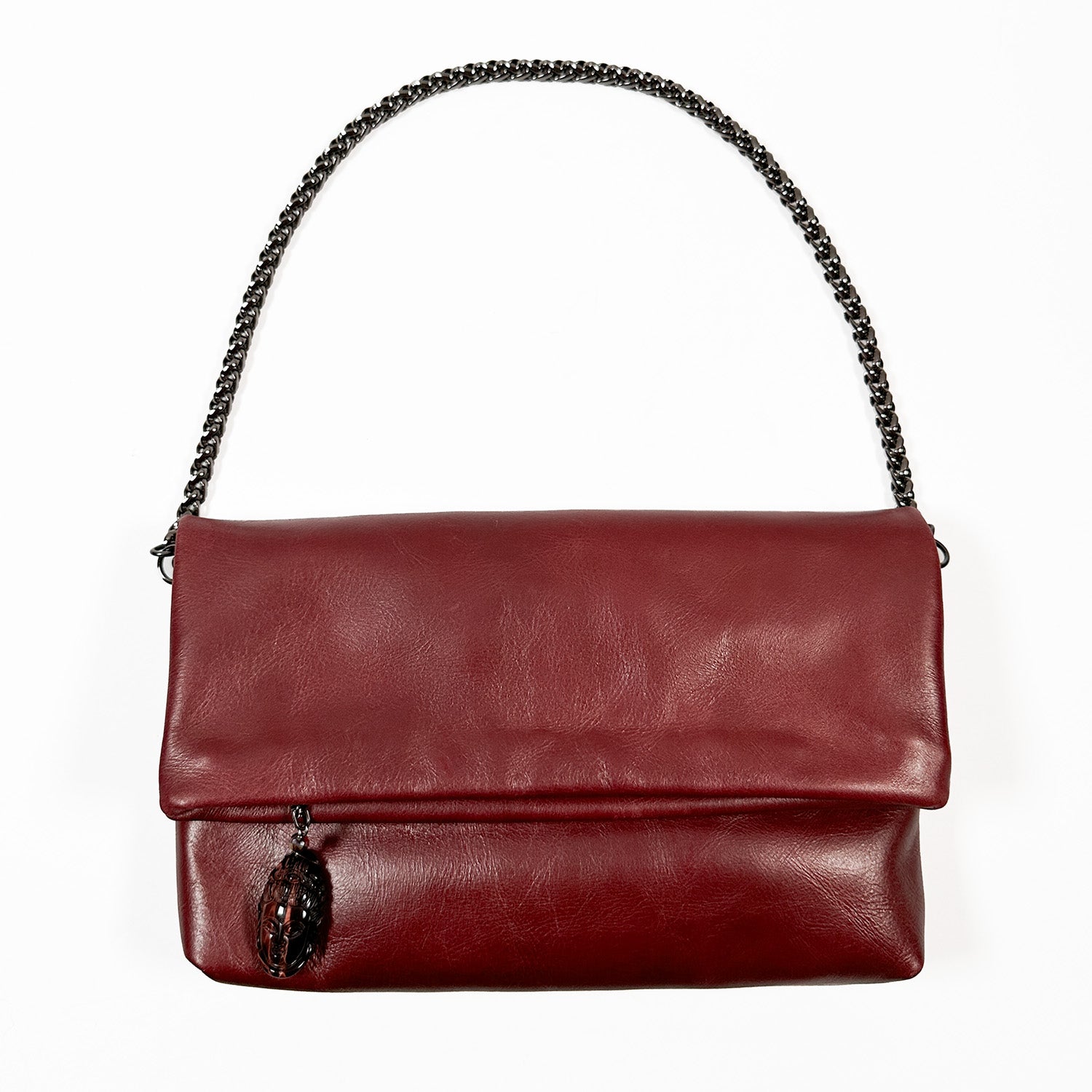 The Farah - wine handbag by evokewomen features a wine-colored leather design with a snake spine chain strap and an ornamental tassel on the front.