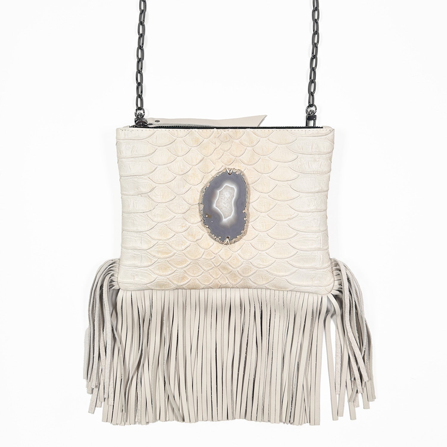 Off-white snake embossed cross-body bag with zipper closure, fringes at bottom, and oval grey/white agate on white background. Gunmetal cross-body chain. 