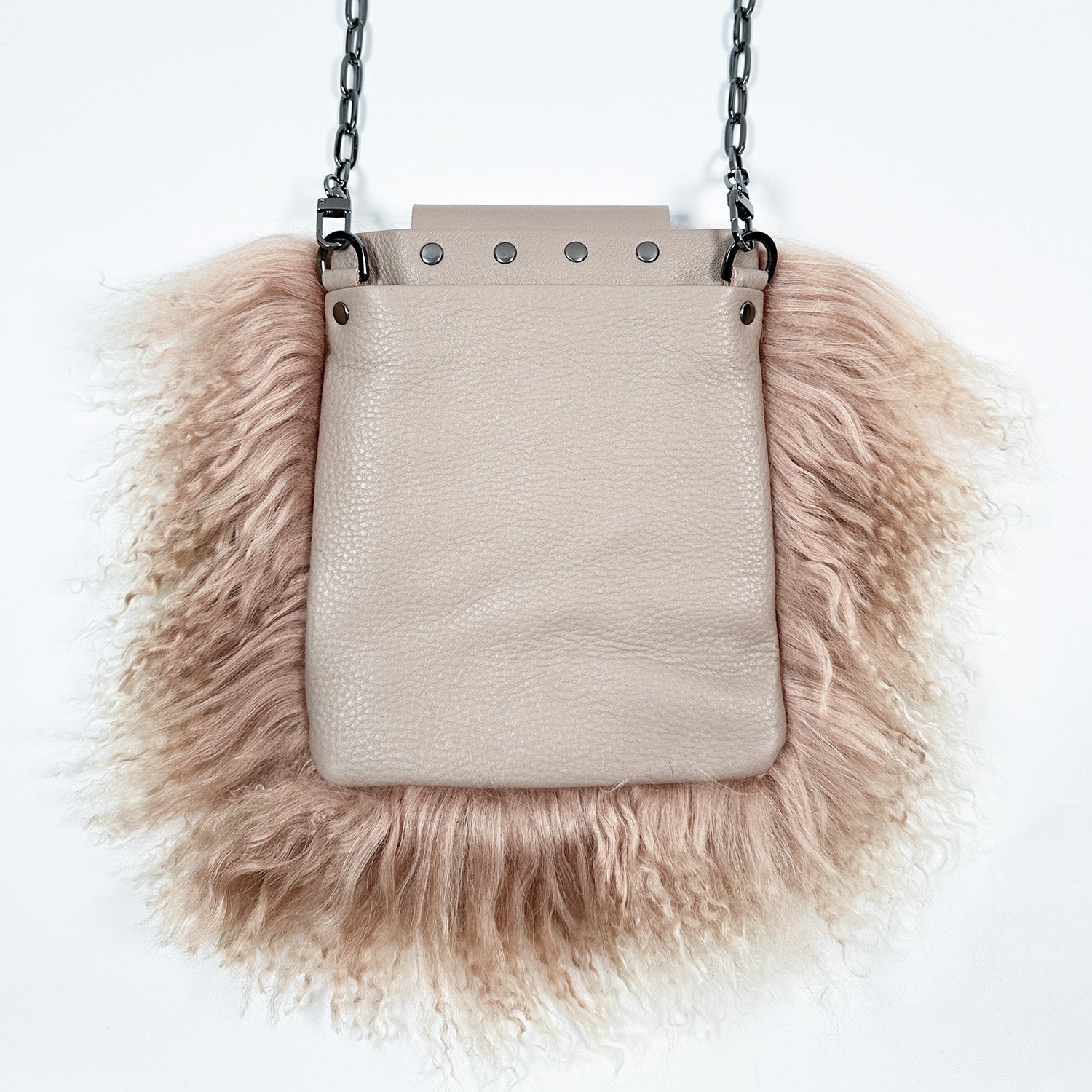 The MIA - BEIGE by evokewomen is a beige leather crossbody bag featuring luxurious Mongolian lamb fur trim and a fashionable chain shoulder strap, ideal for creating a chic statement.