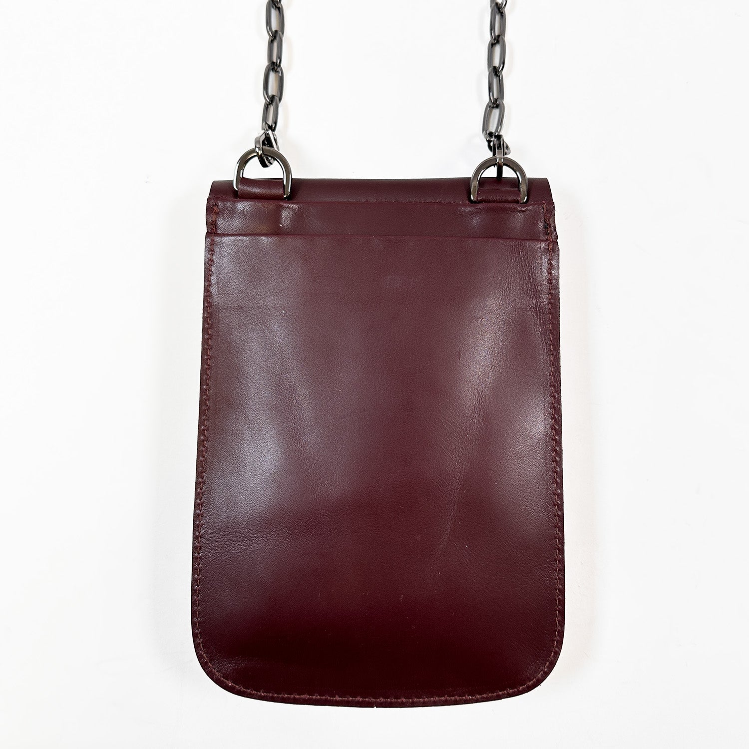 The PAULINA - burgundy by evokewomen, crafted from Italian leather with a metal chain strap, is a festival essential that stands out beautifully against a plain white background.