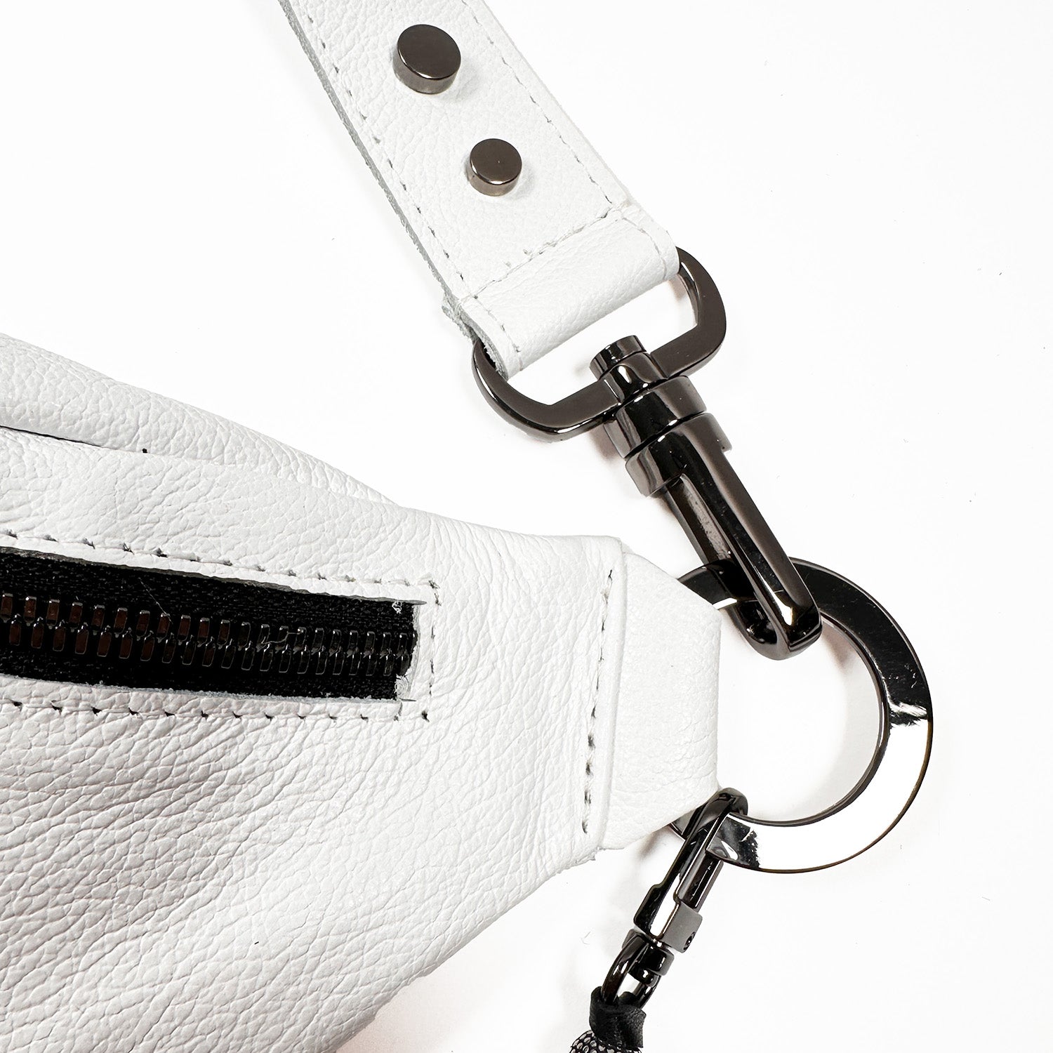 Close-up of the STELLA - white - skull strap by evokewomen, crafted from Italian leather with a metal clasp and two rivets, featuring a sleek design perfect for any sling bag.