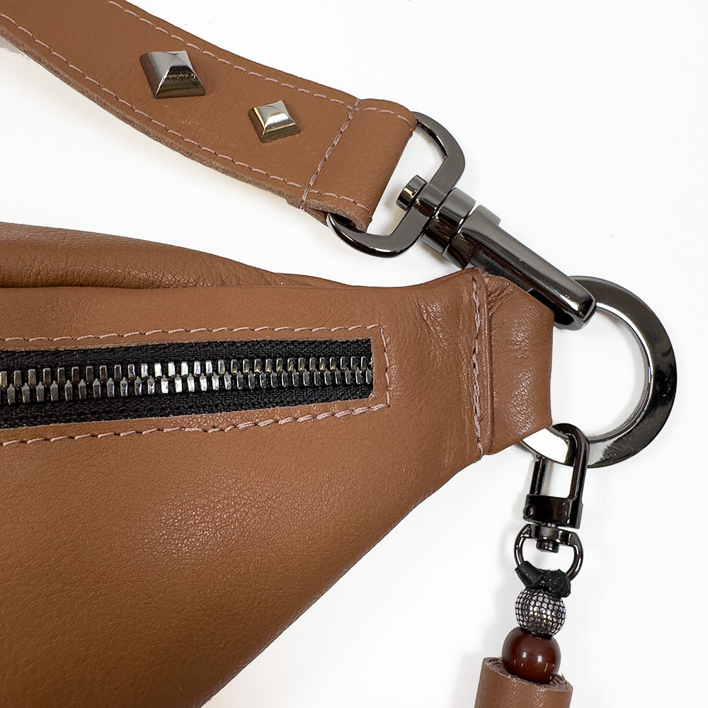 A close-up of the STELLA - western brown sling bag by evokewomen, featuring a zipper, metal clasp, and decorative beads, making it an essential piece in fashion accessories.