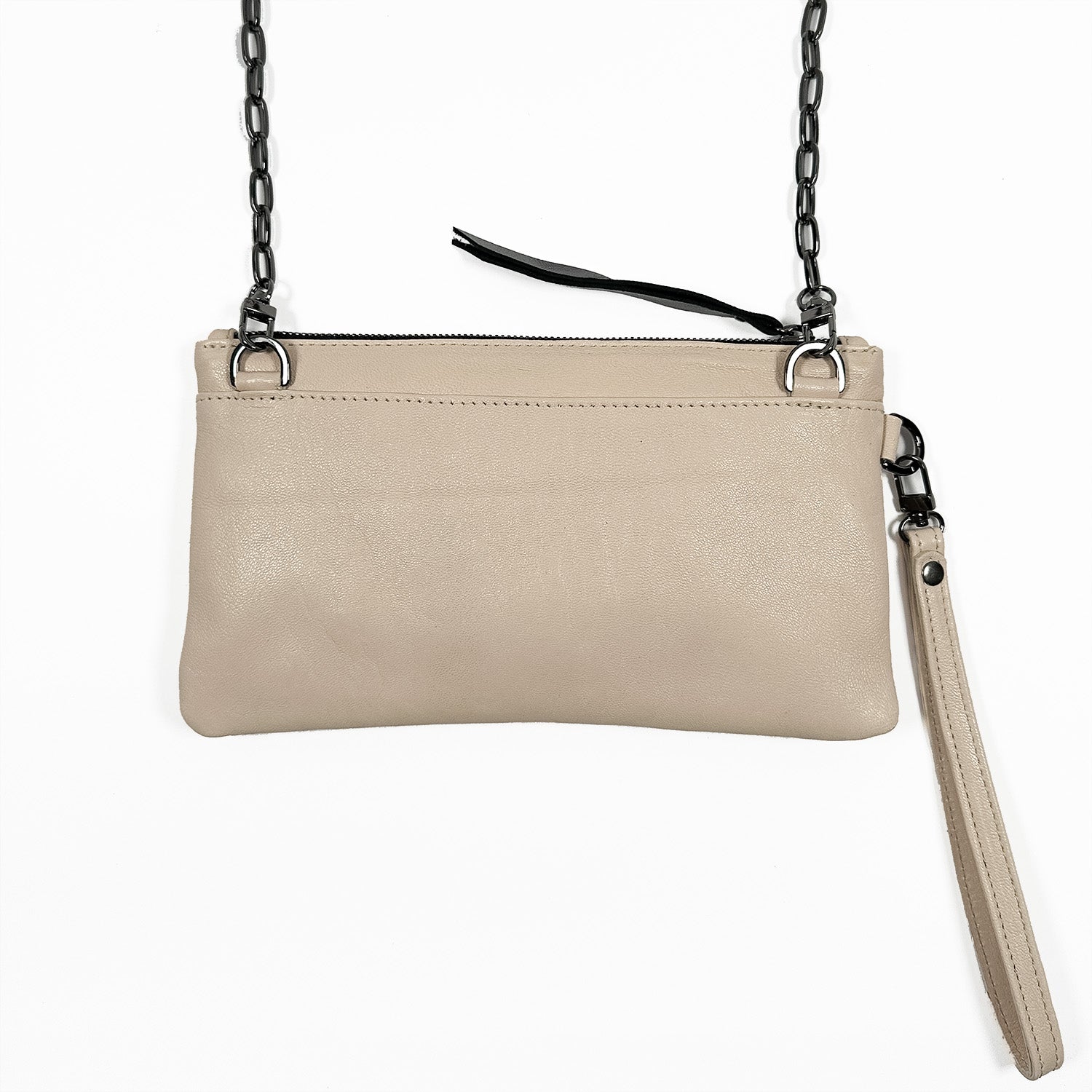 The VICTORIA - almond by evokewomen is a beige leather clutch featuring a chain strap, zipper closure, and a detachable wrist strap, providing the versatility of wearing it as a crossbody bag.