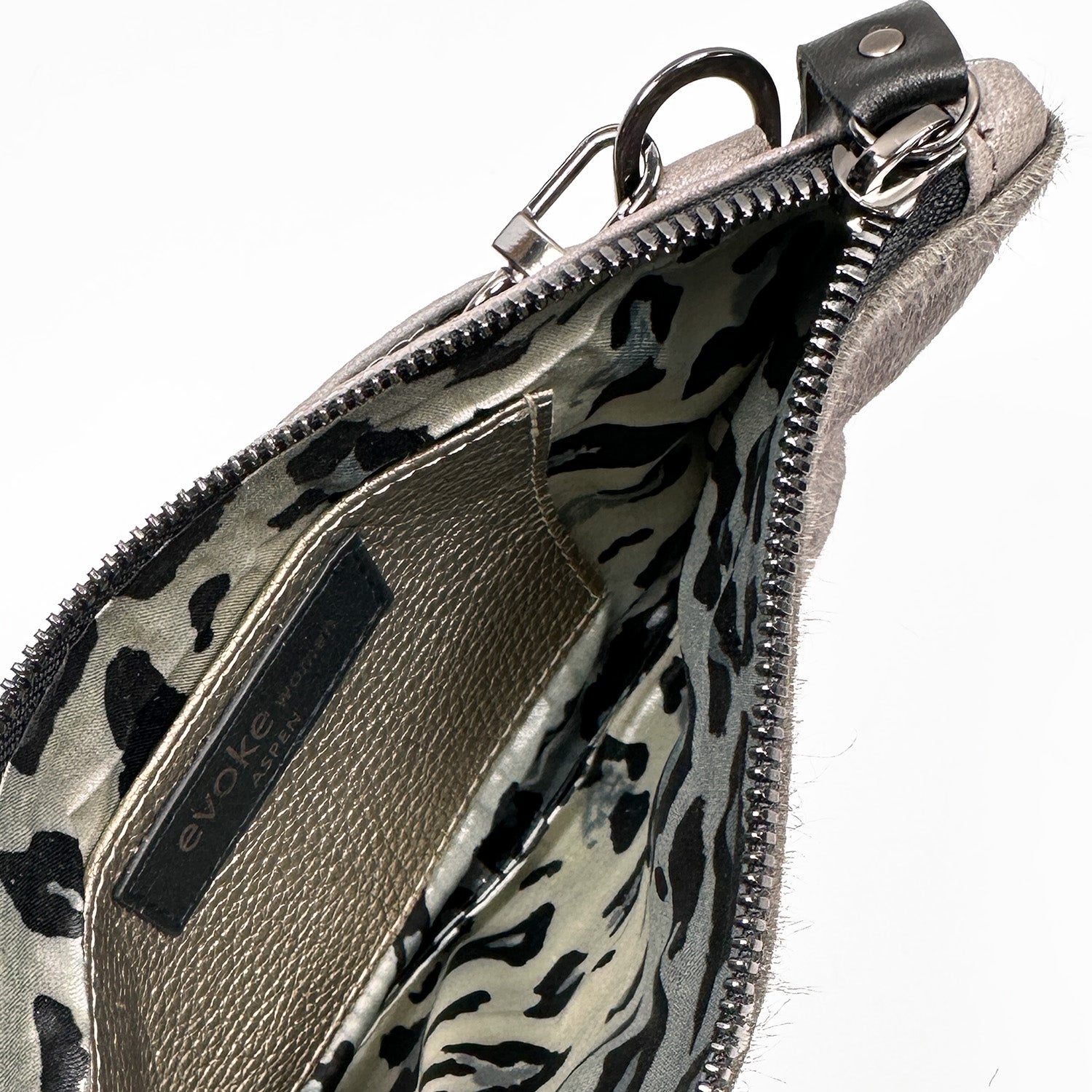 Top view of an open taupe zippered Victoria bag by evokewomen, showcasing a laser mushroom design and a metal clasp on the side, with a leopard print interior.