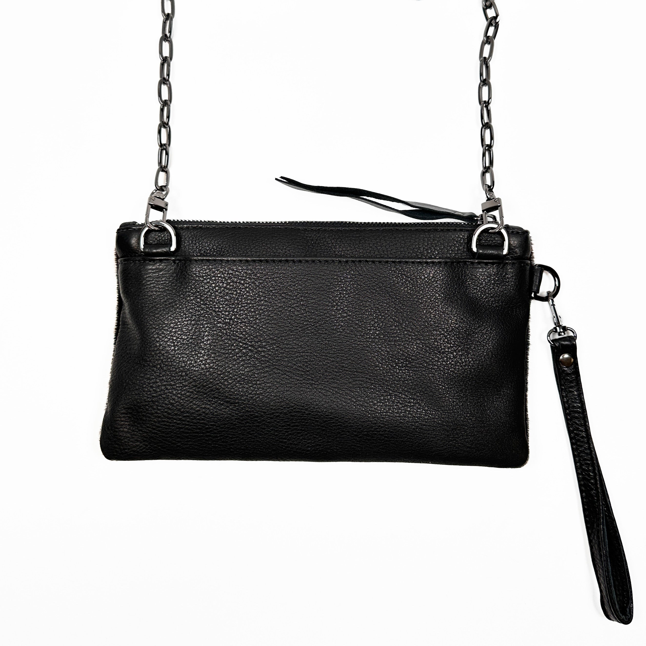 The VICTORIA - black - laser eye clutch by evokewomen, crafted from sleek black leather with a refined silver chain strap and wristlet attachment, is elegantly showcased against a white background.