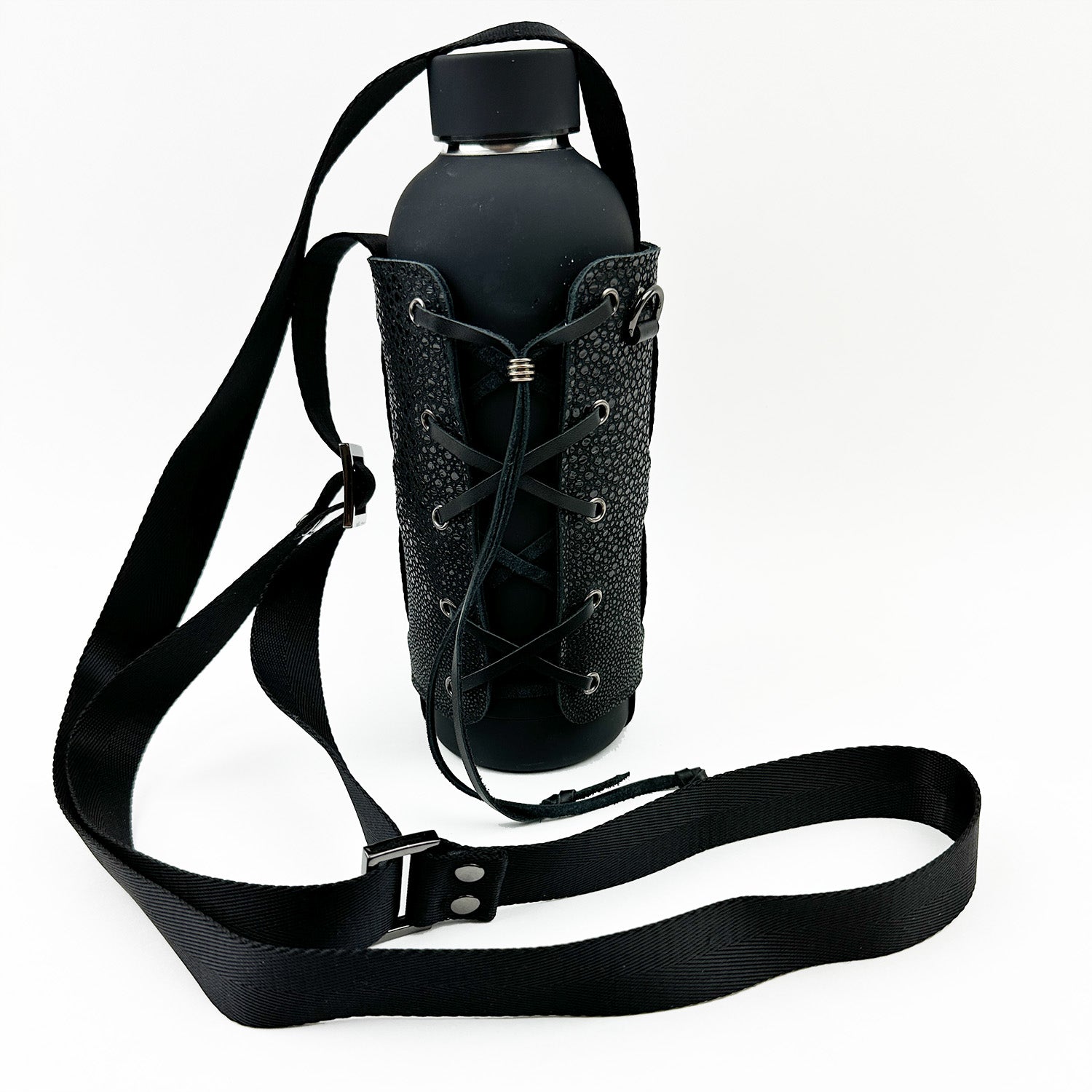 The Bottle Carrier - black Stingray by evokewomen features a textured faux Stingray leather case with a unique lace-up design and an adjustable, detachable shoulder strap for versatile carrying.